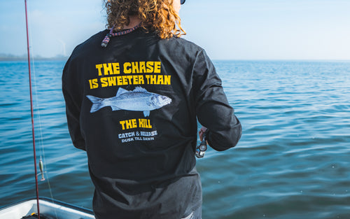 Fishing brand longsleeve black with a Seabass print and the adventurous text the chase is sweeter than the kill