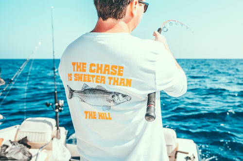 Fishing brand longsleeve white with a Seabass print and the adventurous text the chase is sweeter than the kill