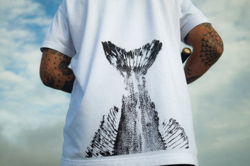 Person wearing a zander print t-shirt with a black fish tail design against a cloudy sky.
